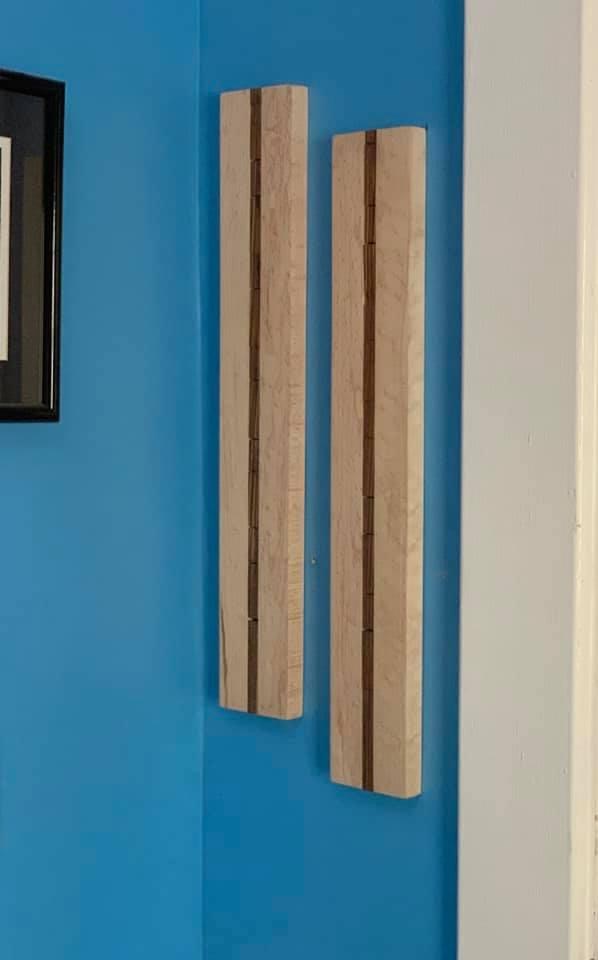 Two maple wall-mounted sunglass racks holding eight pairs of sunglasses