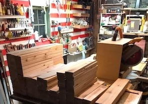Garage workshop with lumber staged on a table saw