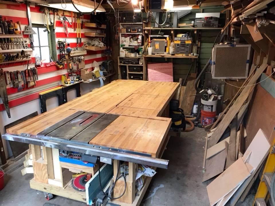 Table saw and workbench loaded with cut cedar boards mid-project